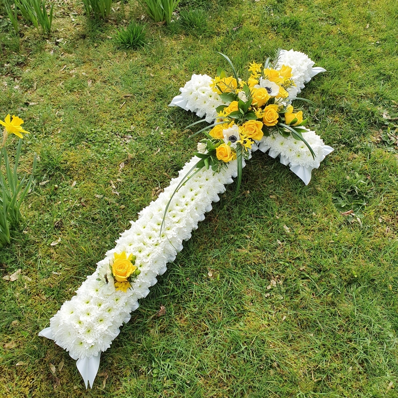 yellow and white based funeral cross