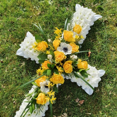 yellow and white based funeral cross