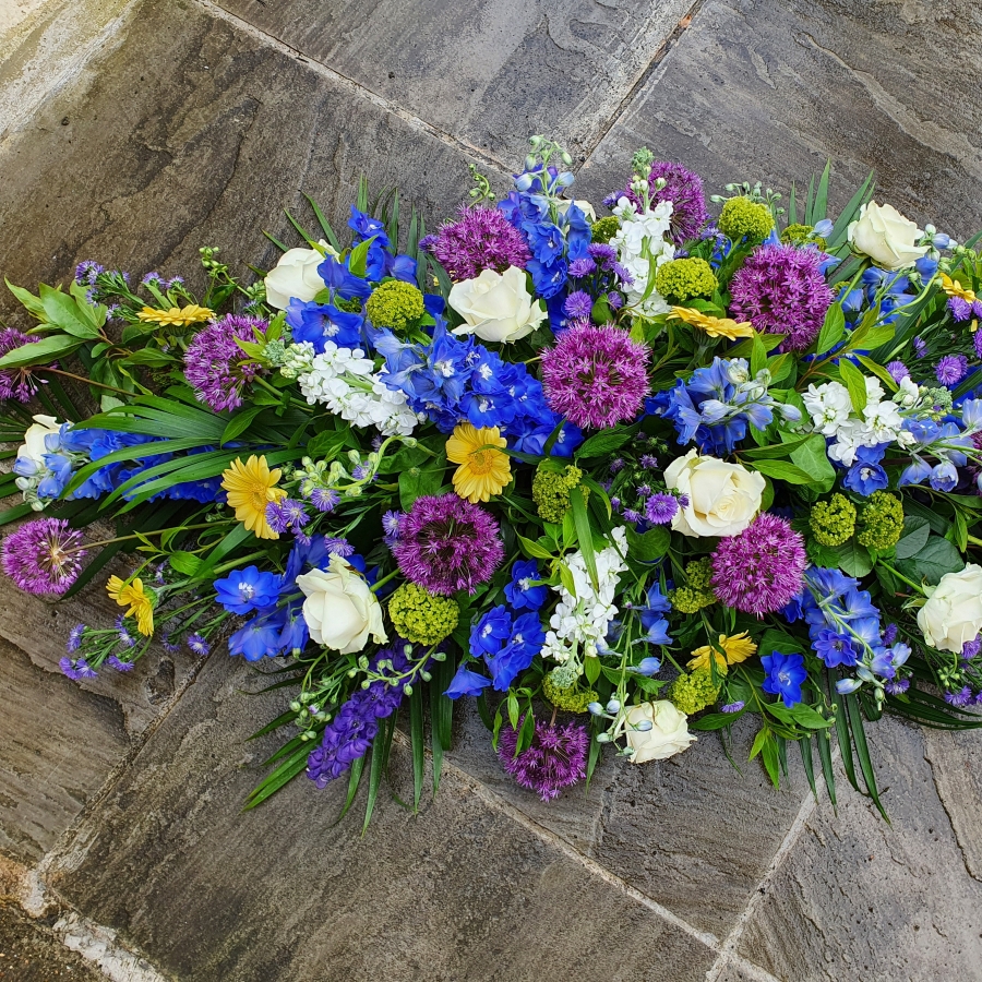 Funeral coffin spray in a mix of Spring Summer flowers and colours
