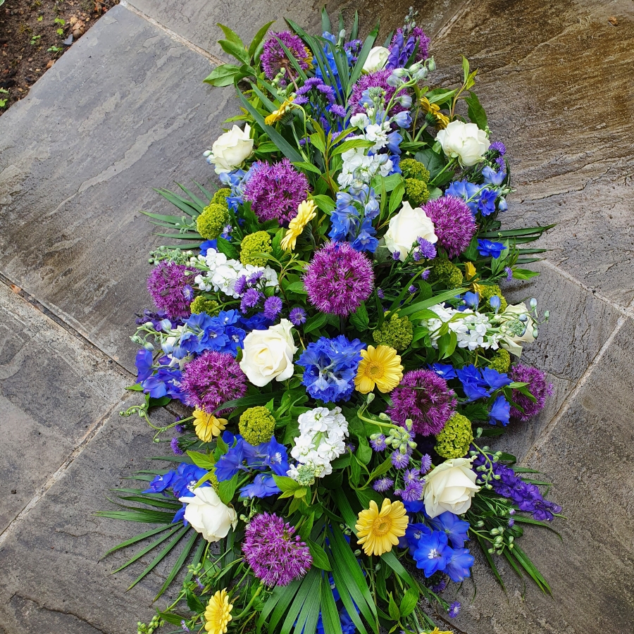 Funeral coffin spray in a mix of Spring Summer flowers and colours