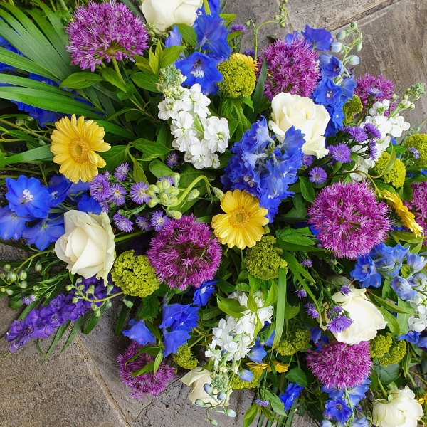 Funeral coffin spray in a mix of Spring Summer flowers and colours
