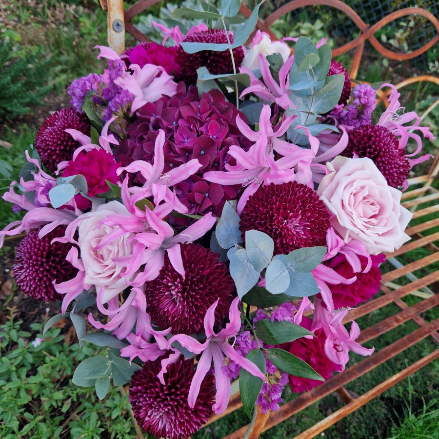 Chyngton autumn bouquet in rich pink and plum tones, featuring nerines, chrysanthemum blooms, roses, carnations, and statice in a lush, seasonal arrangement