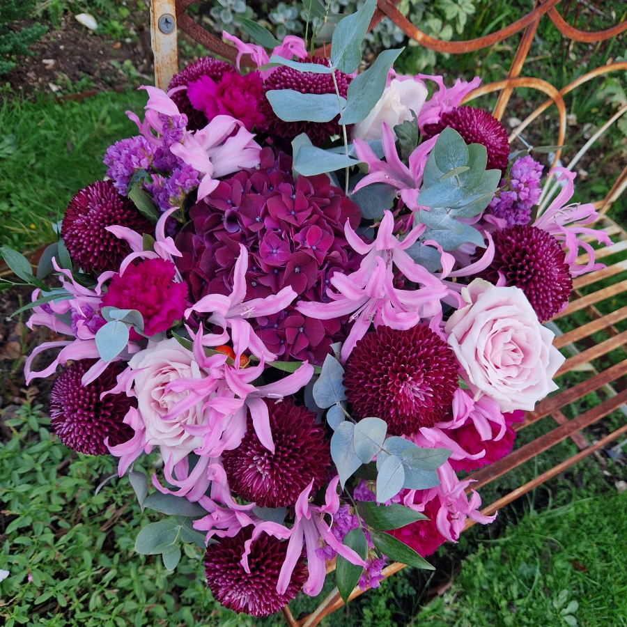 Chyngton autumn bouquet in rich pink and plum tones, featuring nerines, chrysanthemum blooms, roses, carnations, and statice in a lush, seasonal arrangement