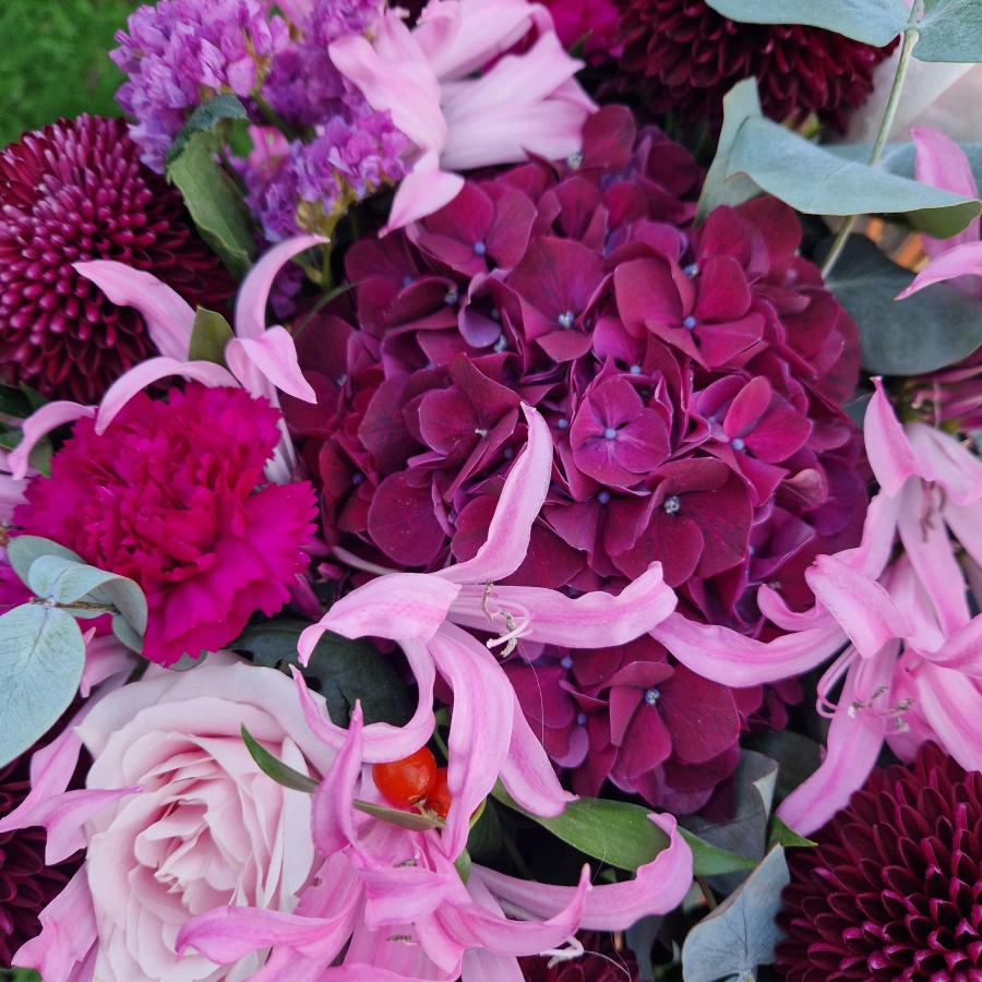 Chyngton autumn bouquet in rich pink and plum tones, featuring nerines, chrysanthemum blooms, roses, carnations, and statice in a lush, seasonal arrangement