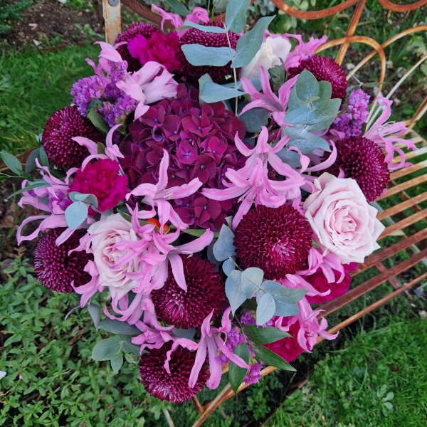 Chyngton autumn bouquet in rich pink and plum tones, featuring nerines, chrysanthemum blooms, roses, carnations, and statice in a lush, seasonal arrangement