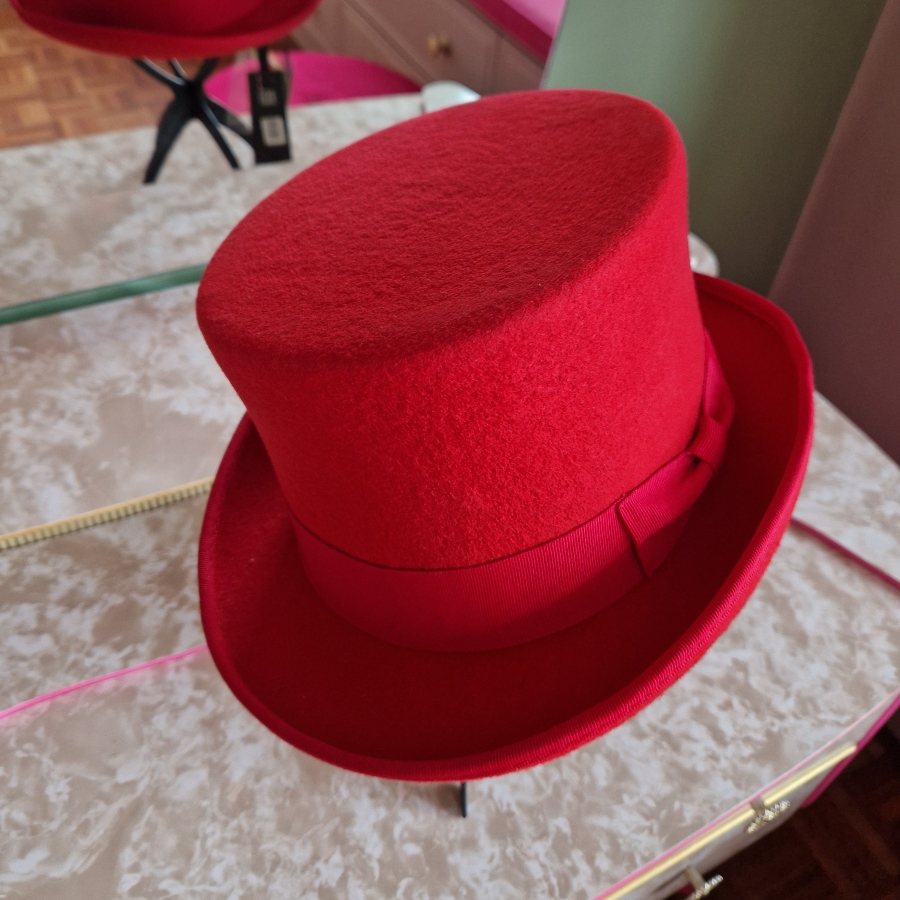 Alternative wedding top hat in red wool with removable floral detail.