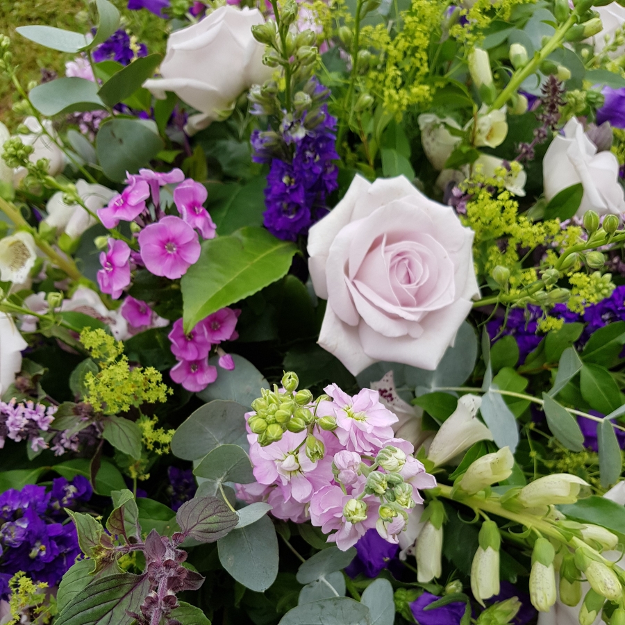 Funeral coffin spray in Lilac and Mauve seasonal flowers