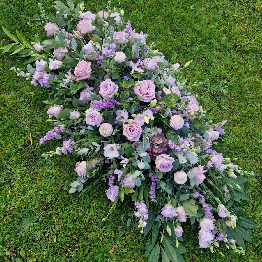 Funeral coffin spray in Lilac and Mauve seasonal flowers