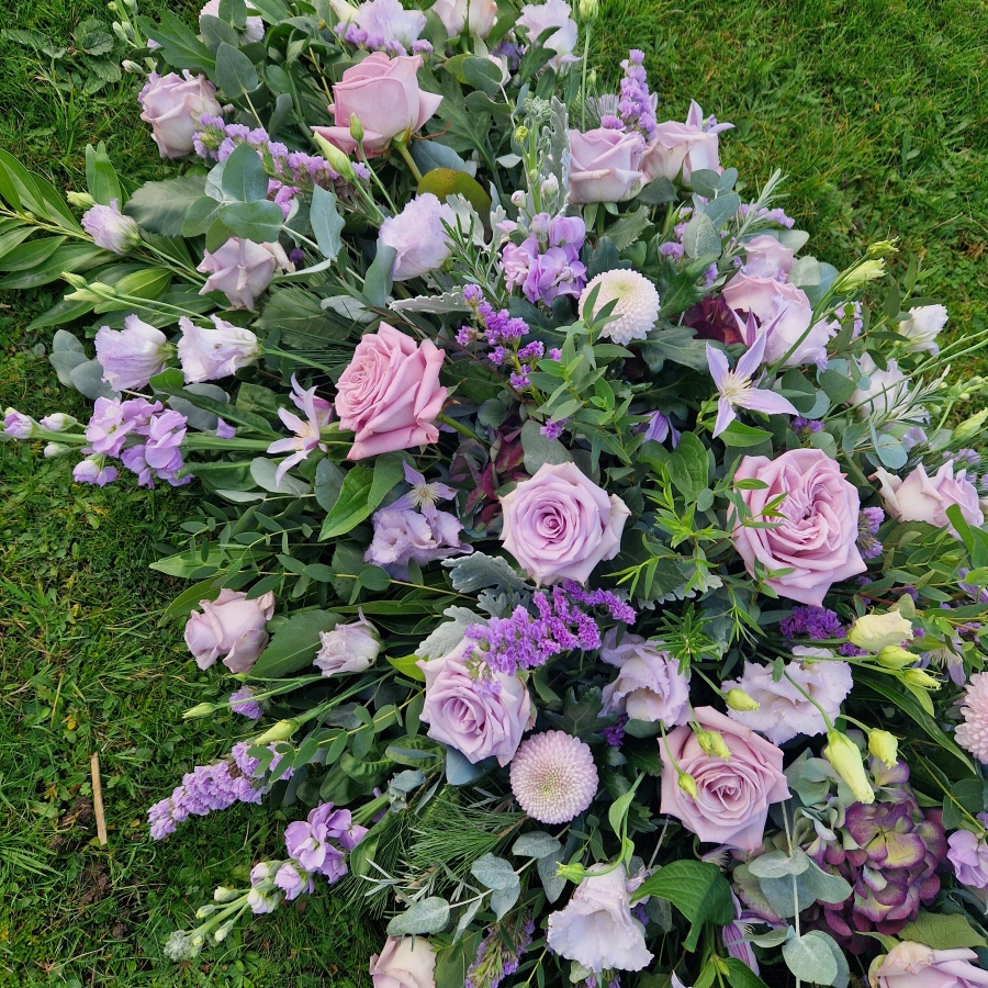 Funeral coffin spray in Lilac and Mauve seasonal flowers