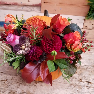 Fresh pumpkin filled with autumn flowers
