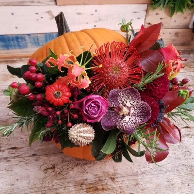 Fresh pumpkin filled with autumn flowers