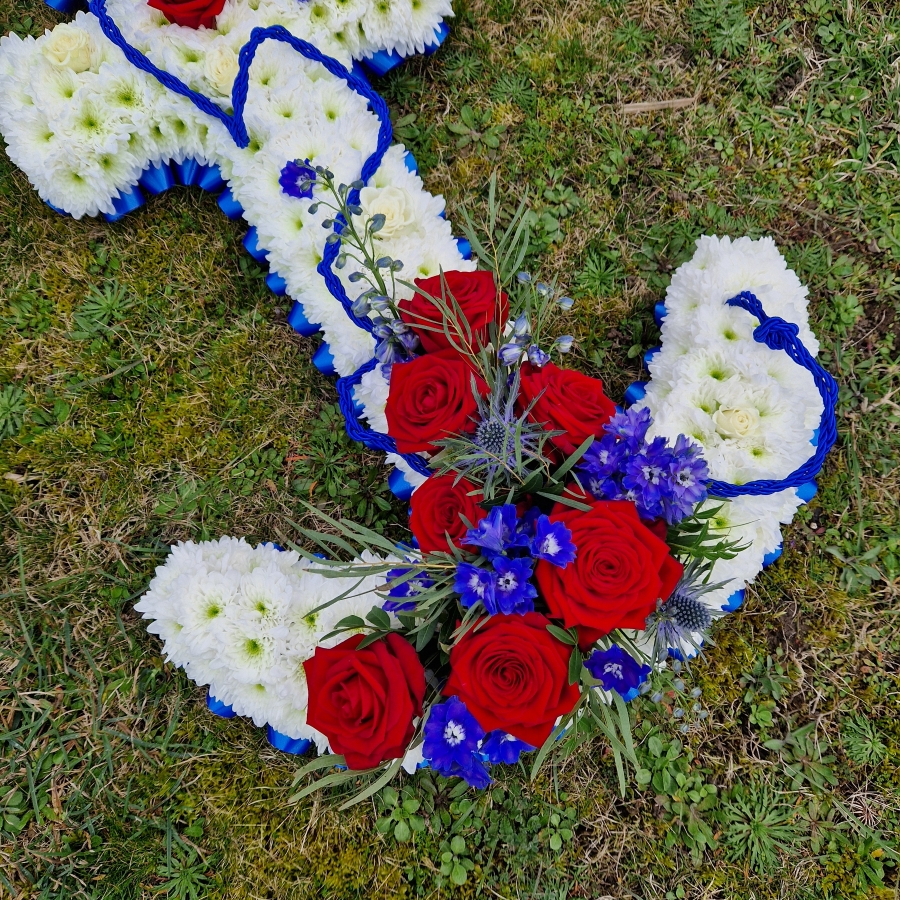 Bespoke funeral tribute in the shape of an anchor in red, white and blue