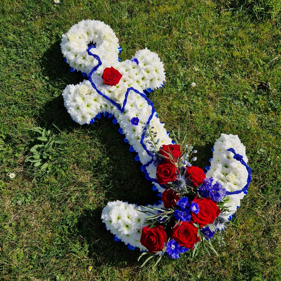 Bespoke funeral tribute in the shape of an anchor in red, white and blue