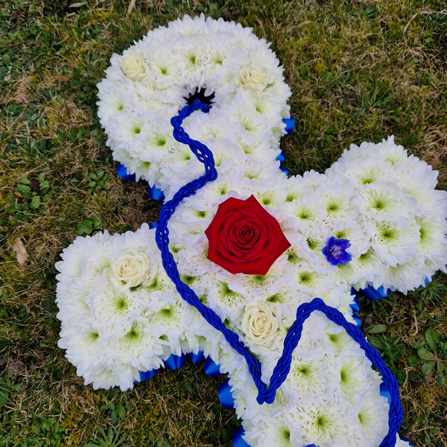 Bespoke funeral tribute in the shape of an anchor in red, white and blue