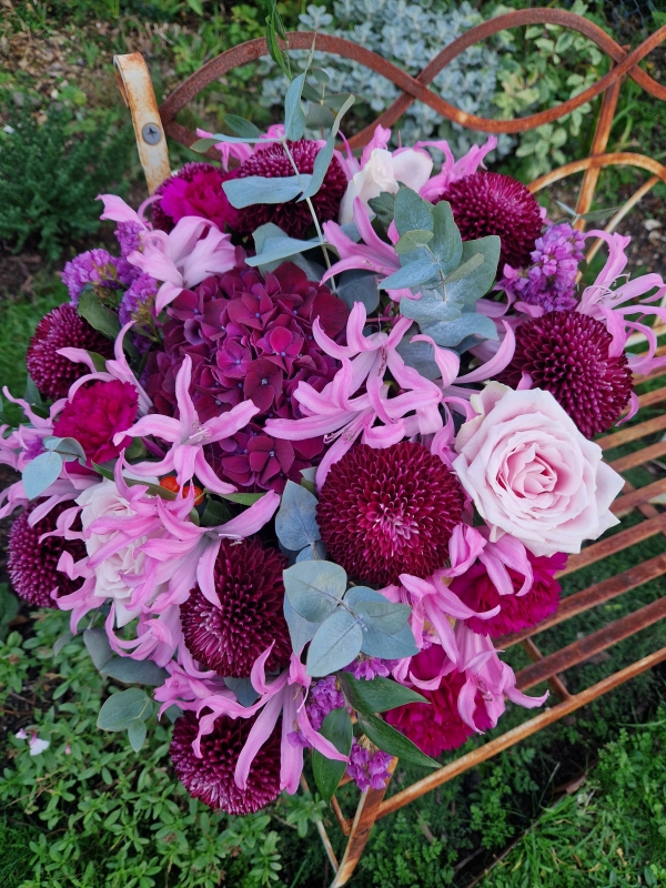 Chyngton autumn bouquet in rich pink and plum tones, featuring nerines, chrysanthemum blooms, roses, carnations, and statice in a lush, seasonal arrangement