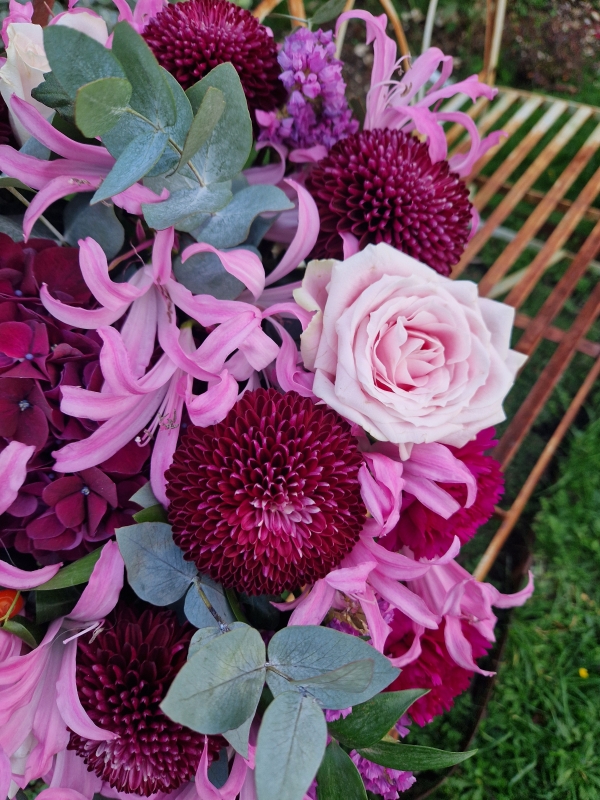 Chyngton autumn bouquet in rich pink and plum tones, featuring nerines, chrysanthemum blooms, roses, carnations, and statice in a lush, seasonal arrangement