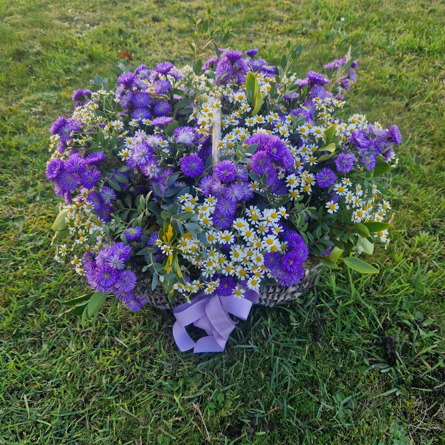 Foam‑free trug arrangement with seasonal daisy‑style flowers, including Michaelmas daisies, asters, Tanacetum, and mixed foliage.