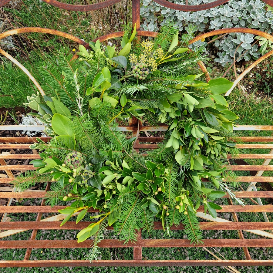 Biodegradable funeral wreath made with seasonal foliage on a mossed base.