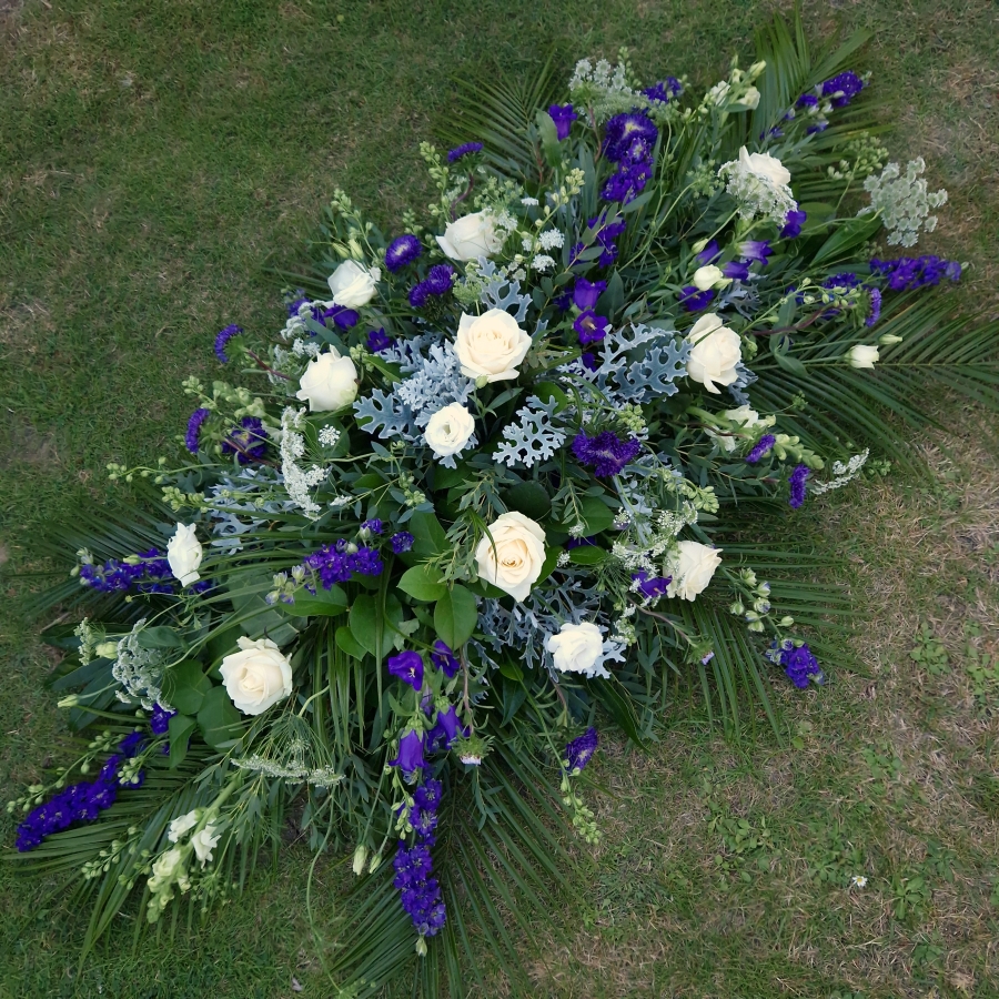 Seasonal coffin spray in purple white flowers