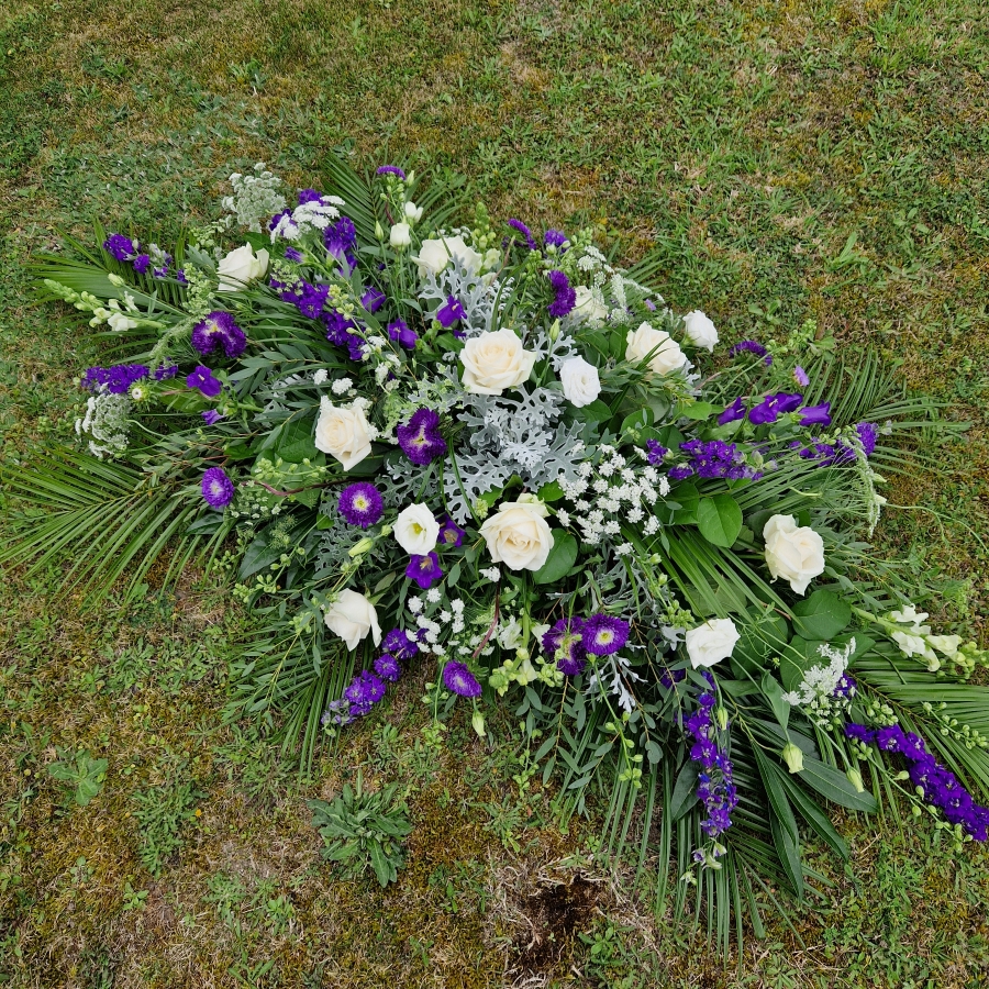 Seasonal coffin spray in purple white flowers