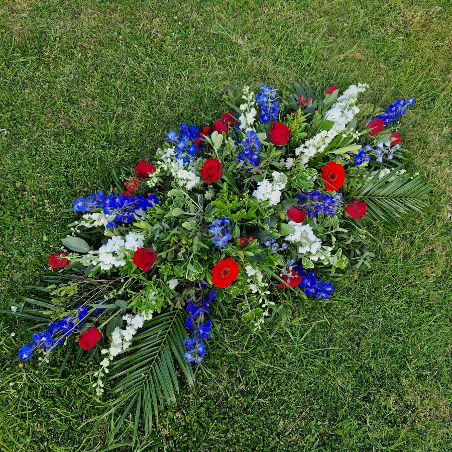 Seasonal coffin spray in red, white and blue flowers