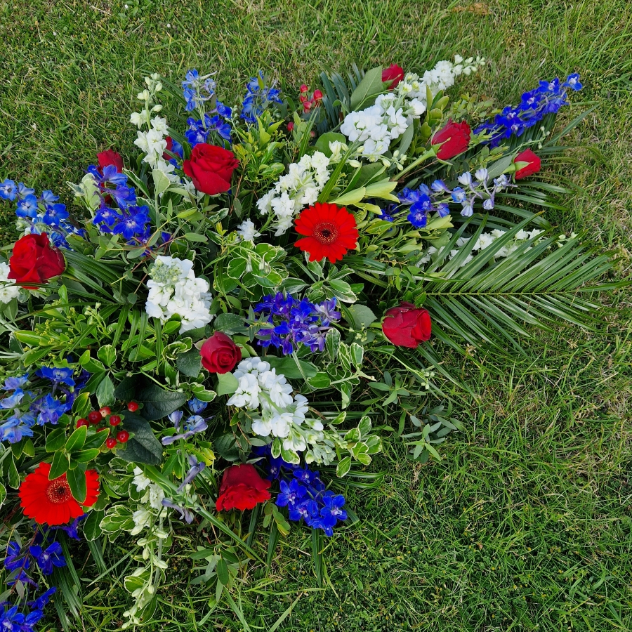 Seasonal coffin spray in red, white and blue flowers