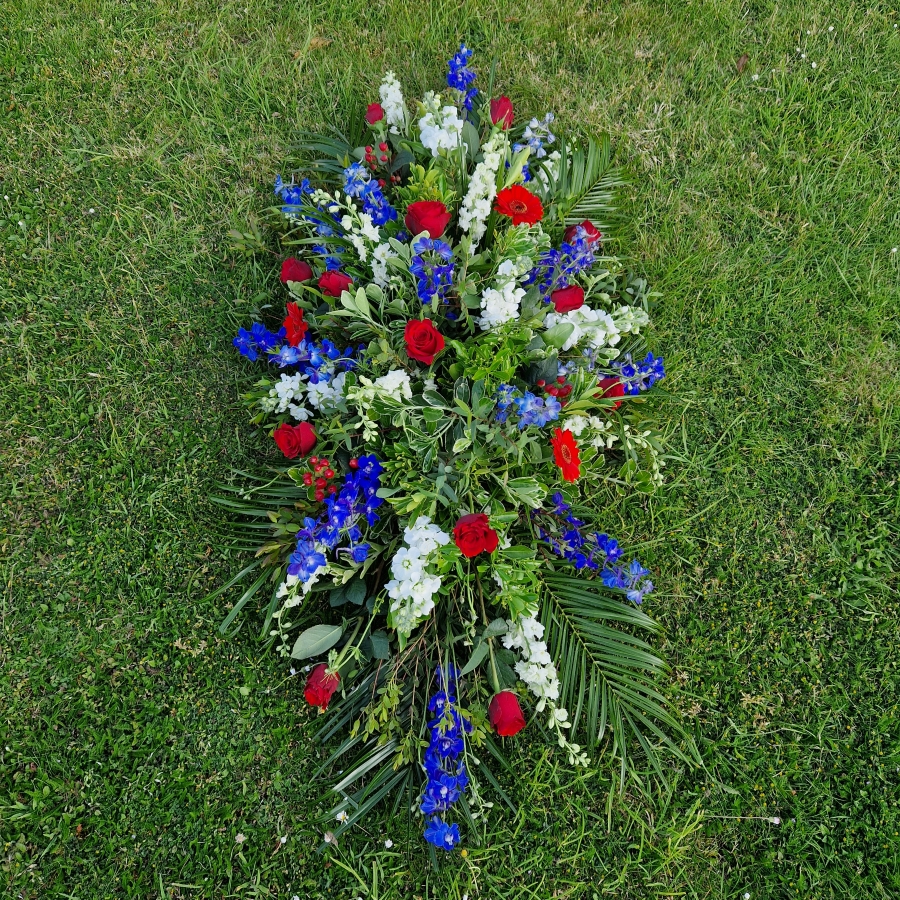 Seasonal coffin spray in red, white and blue flowers