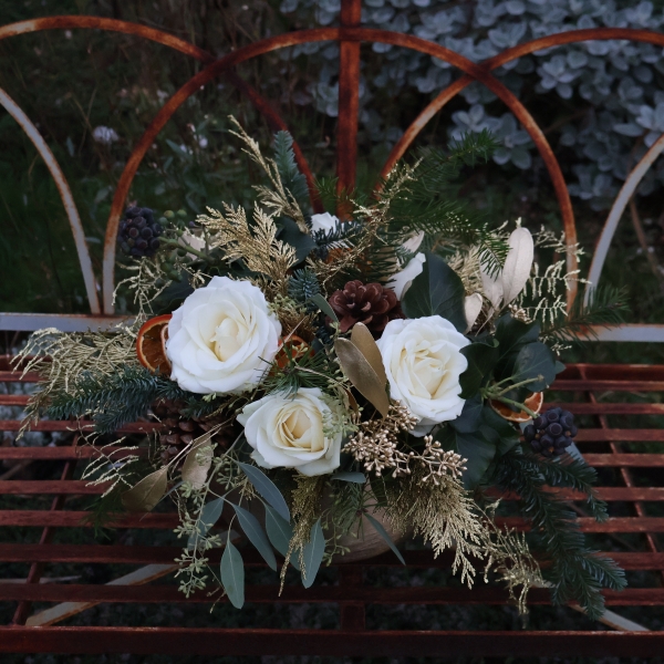 The Gilded Rose arrangement with white roses, gold eucalyptus, fresh pine, conifer, and ivy berry in a brushed gold bowl