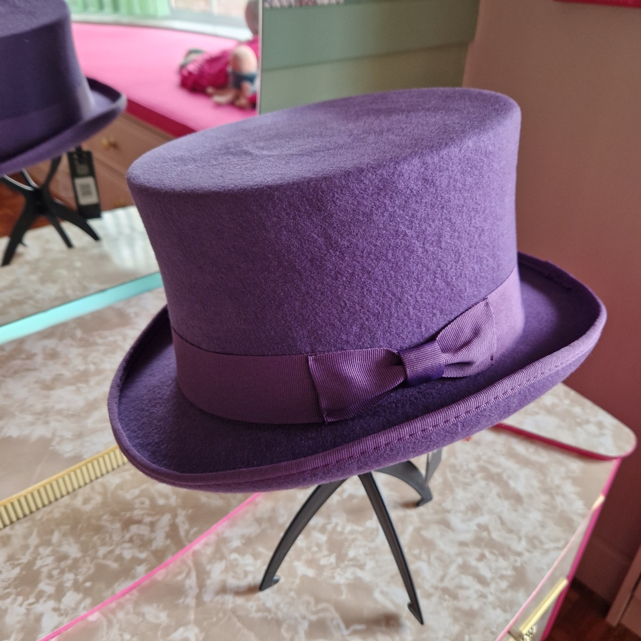 Alternative wedding top hat in purple wool with removable floral detail.