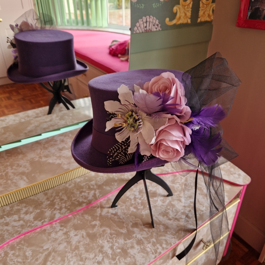 Alternative wedding top hat in purple wool with removable floral detail.