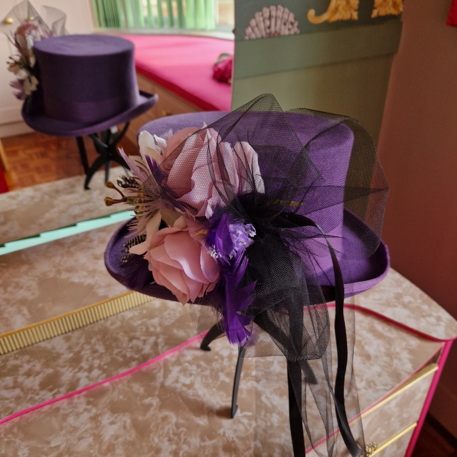 Alternative wedding top hat in purple wool with removable floral detail.