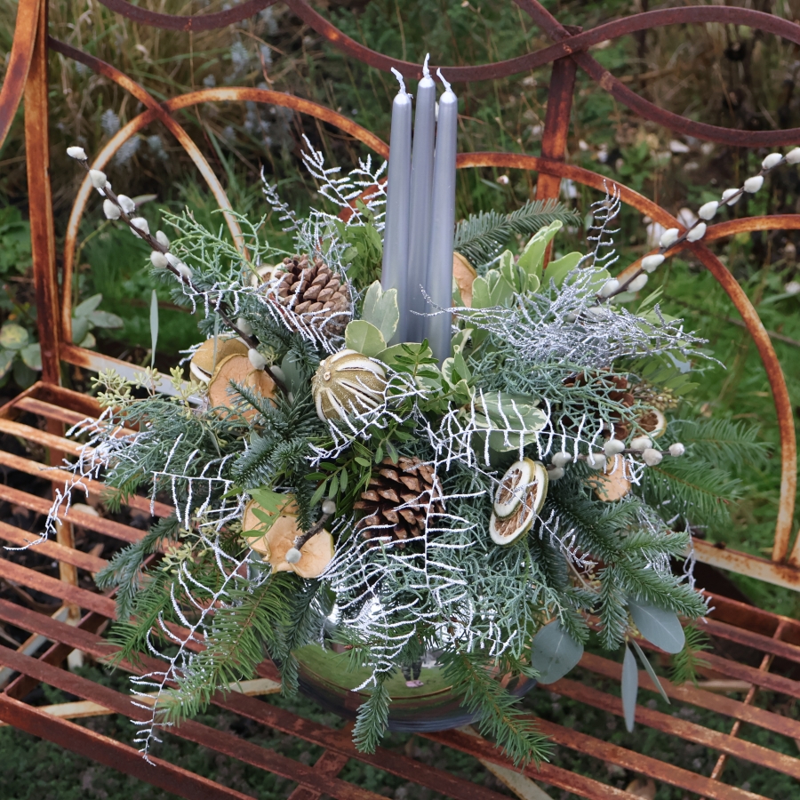 Twinkle Twinkle candle arrangement with silver candles, fresh pine, eucalyptus, dried citrus, and pine cones on a mirrored glass vase.