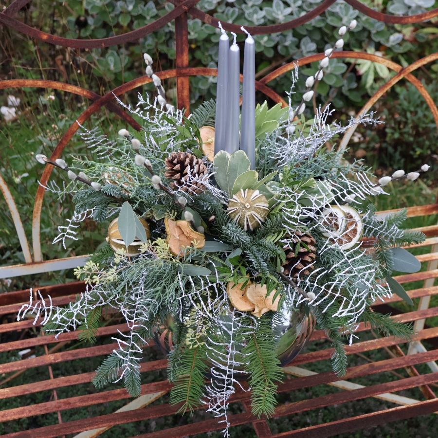 Twinkle Twinkle candle arrangement with silver candles, fresh pine, eucalyptus, dried citrus, and pine cones on a mirrored glass vase.