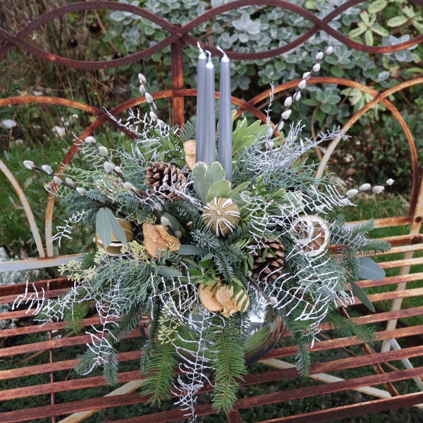 Twinkle Twinkle candle arrangement with silver candles, fresh pine, eucalyptus, dried citrus, and pine cones on a mirrored glass vase.