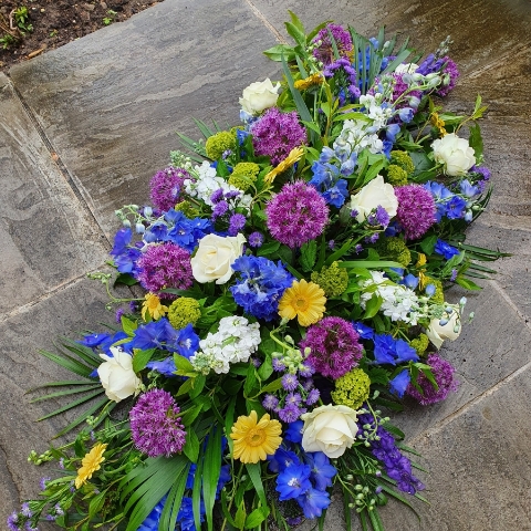 Funeral coffin spray in a mix of Spring Summer flowers and colours