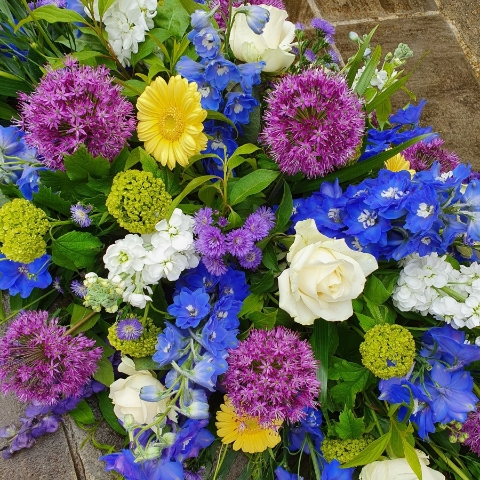 Funeral coffin spray in a mix of Spring Summer flowers and colours