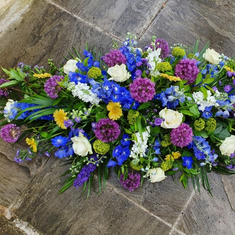 Funeral coffin spray in a mix of Spring Summer flowers and colours