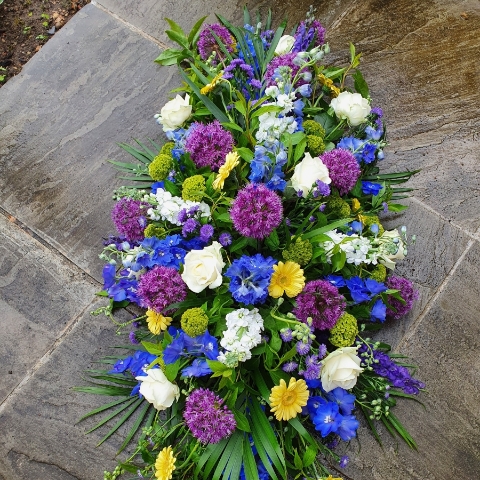 Funeral coffin spray in a mix of Spring Summer flowers and colours