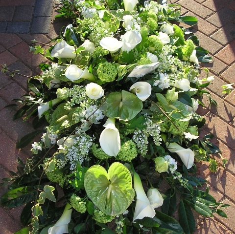 Luxury coffin spray in premium green and white flowers including anthuriums and callas