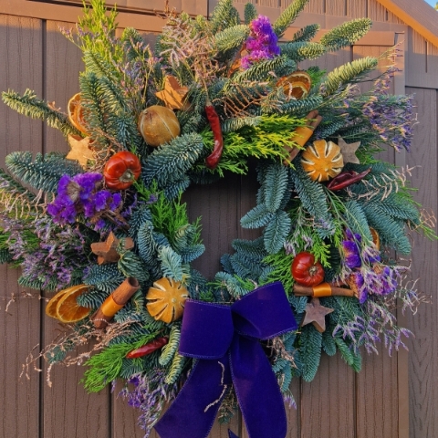 Fruit & Nut Christmas wreath with fresh pine, dried fruits, cinnamon sticks, chillies, coconut stars, copper coral fern, purple Limonium, and velvet bow