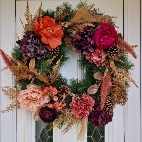 Faux flower Christmas wreath with peonies, hydrangeas, ranunculus, skimmia, pine cones, and gold accents on a 50cm faux pine ring