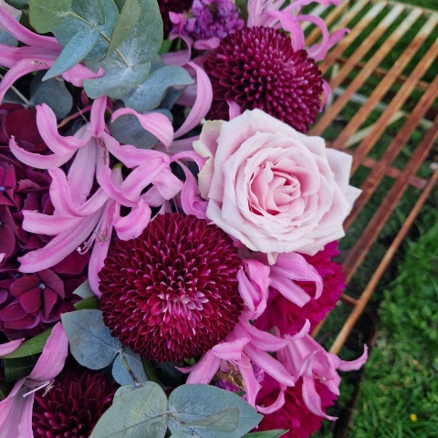 Chyngton autumn bouquet in rich pink and plum tones, featuring nerines, chrysanthemum blooms, roses, carnations, and statice in a lush, seasonal arrangement