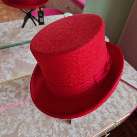 Alternative wedding top hat in red wool with removable floral detail.