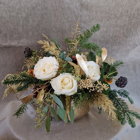 The Gilded Rose arrangement with white roses, gold eucalyptus, fresh pine, conifer, and ivy berry in a brushed gold bowl