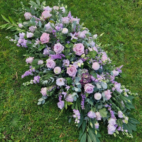 Funeral coffin spray in Lilac and Mauve seasonal flowers