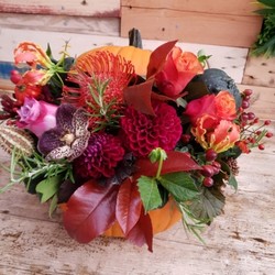 Fresh pumpkin filled with autumn flowers