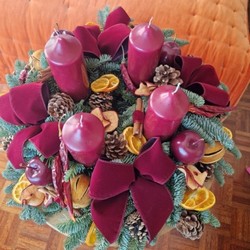 Luxury Christmas advent wreath with four burgundy pillar candles, velvet bows, fresh Nobilis pine, pine cones, cinnamon sticks, dried orange and apple slices, chillies, and waxed apples