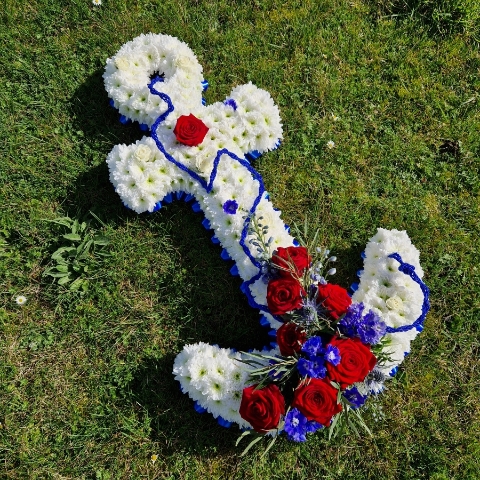 Bespoke funeral tribute in the shape of an anchor in red, white and blue