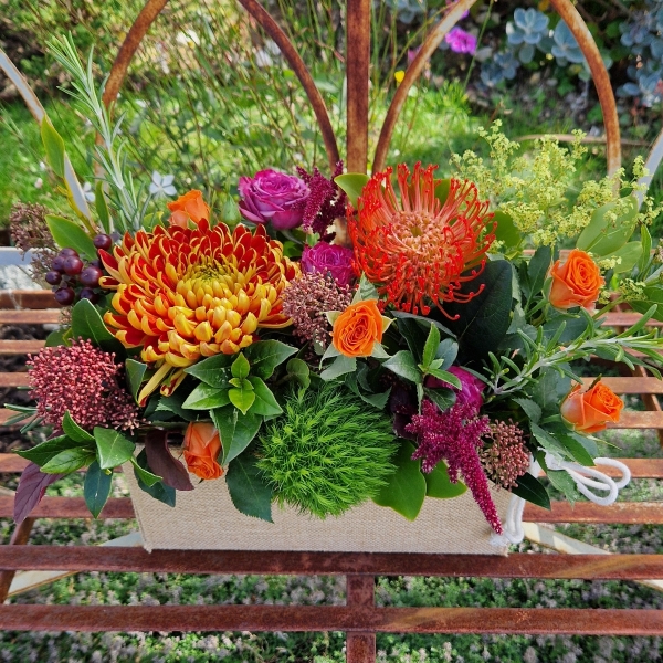 Autumn Downs jute trough arrangement with rust chrysanthemums, roses, seasonal berries and grasses