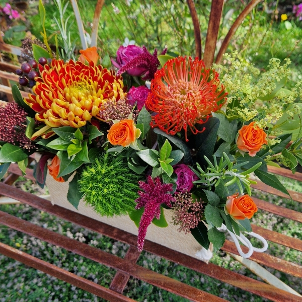 Autumn Downs jute trough arrangement with rust chrysanthemums, roses, seasonal berries and grasses